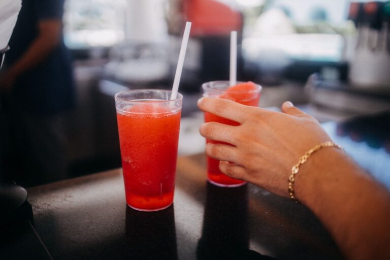 Hand reaching for a red slushie drink